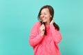 Pretty smiling young woman in knitted pink sweater with closed eyes holding in hand watermelon lollipop isolated on blue Royalty Free Stock Photo