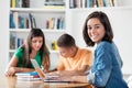 Pretty spanish female student with group of learning students