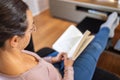 Pretty spanish women reading at home on the sofa