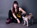 Pretty sport girl with pug dog in studio Royalty Free Stock Photo