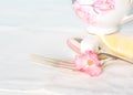 Tea Cup, Fork and Spoon with sugar cube and lemon on white table cloth Royalty Free Stock Photo