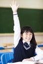 Pretty student girl raising hand in classroom Royalty Free Stock Photo