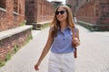 Pretty stylish tourist woman walking in medieval city of Verona, Italy