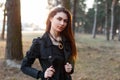 Pretty stylish woman in a black cloak walking in the park Royalty Free Stock Photo