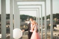 Pretty sunny outdoor portrait of young stylish couple while kissing on the roof with city view Royalty Free Stock Photo