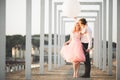 Pretty sunny outdoor portrait of young stylish couple while kissing on the roof with city view Royalty Free Stock Photo