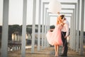 Pretty sunny outdoor portrait of young stylish couple while kissing on the roof with city view Royalty Free Stock Photo