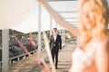 Pretty sunny outdoor portrait of young stylish couple while kissing on the roof with city view Royalty Free Stock Photo