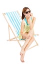 Pretty sunshine girl smiling and sitting on a beach chair Royalty Free Stock Photo