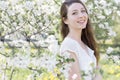 Pretty sweet tender young girl with a bright smile with long blond hair among the blossoming apple trees Royalty Free Stock Photo