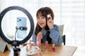 A talented young Asian girl is showing kid cosmetic products while recording her makeup tutorial