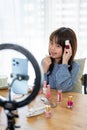 A talented young Asian girl is showing kid cosmetic products while recording her makeup tutorial