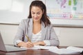 Pretty teacher correcting at her desk in a classroom