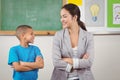 Pretty teacher and cute pupil in front of chalkboard