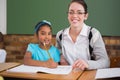 Pretty teacher helping pupil in classroom Royalty Free Stock Photo