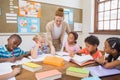 Pretty teacher helping pupils in classroom Royalty Free Stock Photo