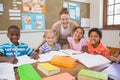 Pretty teacher helping pupils in classroom Royalty Free Stock Photo