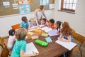 Pretty teacher helping pupils in classroom Royalty Free Stock Photo