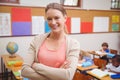 Pretty teacher smiling at camera with arms crossed Royalty Free Stock Photo