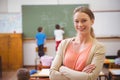 Pretty teacher smiling at camera at back of classroom