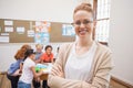 Pretty teacher smiling at camera at top of classroom Royalty Free Stock Photo