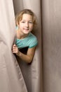 Girl peeping from behind curtains Royalty Free Stock Photo