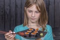 Pretty teen girl with sushi roll closeup portrait, teenage girl eating japanese sushi