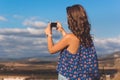 Pretty teen girl taking photo of nature by phone Royalty Free Stock Photo
