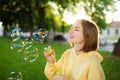 Pretty teenage girl blowing soap bubbles on a sunset. Child having fun in a park in summer Royalty Free Stock Photo