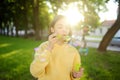 Pretty teenage girl blowing soap bubbles on a sunset. Child having fun in a park in summer Royalty Free Stock Photo