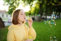 Pretty teenage girl blowing soap bubbles on a sunset. Child having fun in a park in summer Royalty Free Stock Photo