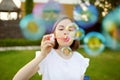 Pretty teenage girl blowing soap bubbles on a sunset. Child having fun in a park in summer Royalty Free Stock Photo