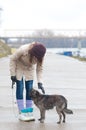 Pretty teenage girl with dog on cloudy winter day