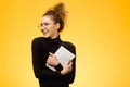 Pretty teenage girl with happy face on yellow background