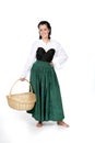 Pretty teenage girl in period dress holding basket Royalty Free Stock Photo