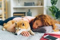 Pretty teenage girl sleeping at home hugging adorable shiba inu dog in sleep