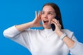 Pretty teenage girl talking on the mobile phone against blue background Royalty Free Stock Photo