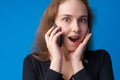 Pretty teenage girl talking on the mobile phone against blue background Royalty Free Stock Photo