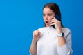 Pretty teenage girl talking on the mobile phone against blue background Royalty Free Stock Photo