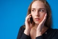 Pretty teenage girl talking on the mobile phone against blue background Royalty Free Stock Photo