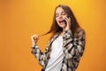 Pretty teenage girl talking on the mobile phone against yellow background Royalty Free Stock Photo