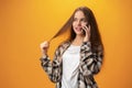 Pretty teenage girl talking on the mobile phone against yellow background Royalty Free Stock Photo