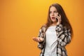 Pretty teenage girl talking on the mobile phone against yellow background Royalty Free Stock Photo