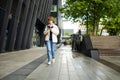 Teenage girl using a smart phone. Beautiful young girl in a city park on autumn day. Teenagers addiction to new technology Royalty Free Stock Photo