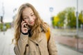 Teenage girl using a smart phone. Beautiful young girl in a city park on autumn day. Teenagers addiction to new technology Royalty Free Stock Photo