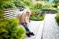 Pretty teenage girl 14-16 year old with curly long blonde hair and in glasses in the green park in a summer day outdoors. Royalty Free Stock Photo