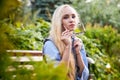 Pretty teenage girl 14-16 year old with curly long blonde hair and in glasses in the green park in a summer day outdoors. Royalty Free Stock Photo