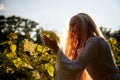 Pretty teenage girl 14-16 year old with curly long blonde hair in the green park with white flower in a summer day outdoors and Royalty Free Stock Photo