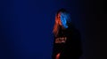 Pretty teenage model in studio with blue and orange light. Model enjoying a photo shoot. Withc copy space
