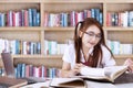 Pretty teenage student learns in library Royalty Free Stock Photo